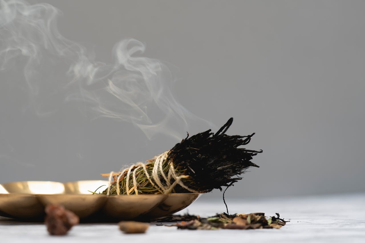 Calm and spiritual atmosphere with sage smudge burning in a ritual setting.